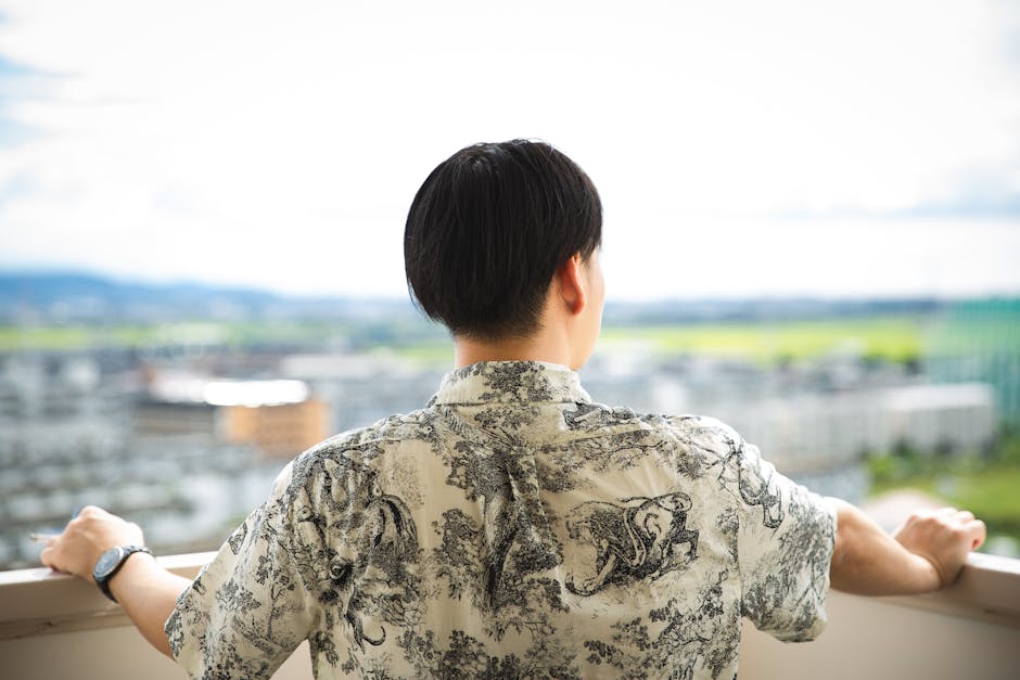 緑の街に対してオープンバルコニーに立っている認識できない男