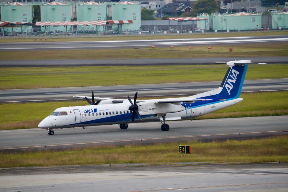混雑した空港の滑走路をタキシングするANAの航空機。航空活動を展示しています。