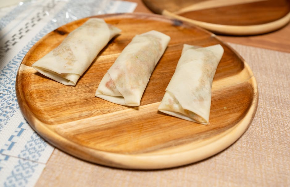 作りたての春巻き3本が木製の皿に上品に盛り付けられており、アジア料理好きにはたまらない逸品です。