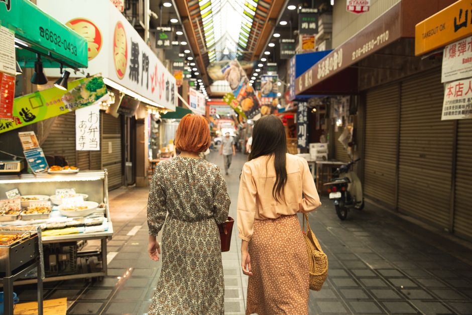 アジア市場を歩く匿名のスタイリッシュな女性の友人