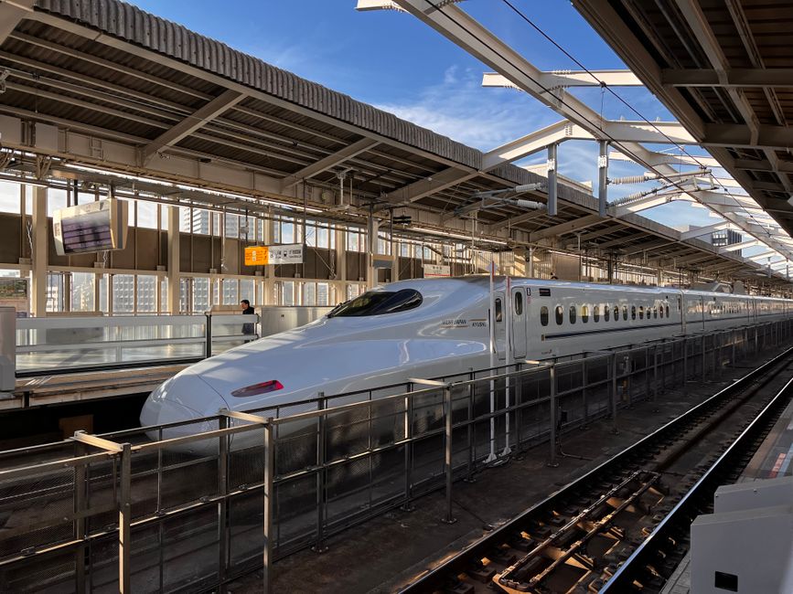 日中、日本の大阪のホームに停車する高速新幹線。