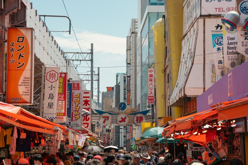 東京・アメ横の活気あふれる露店街の様子。色とりどりの看板と賑やかな人々で活気に満ちている。
