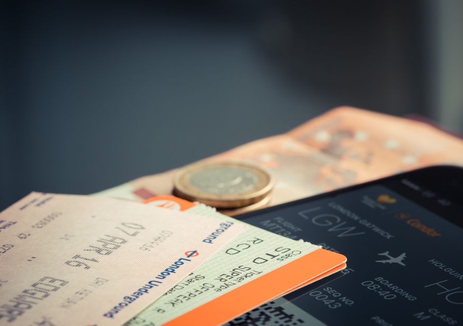 ユーロ硬貨とフライト詳細を表示するスマートフォンを備えた航空券。