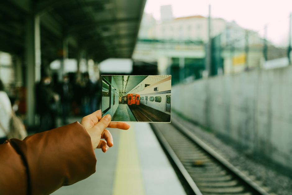 ある人がトルコのイスタンブールの駅のプラットフォームで列車の写真を持っています。