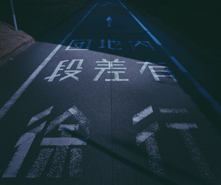 興味深い道路標示がある夜の雰囲気漂う日本の都市の通り。