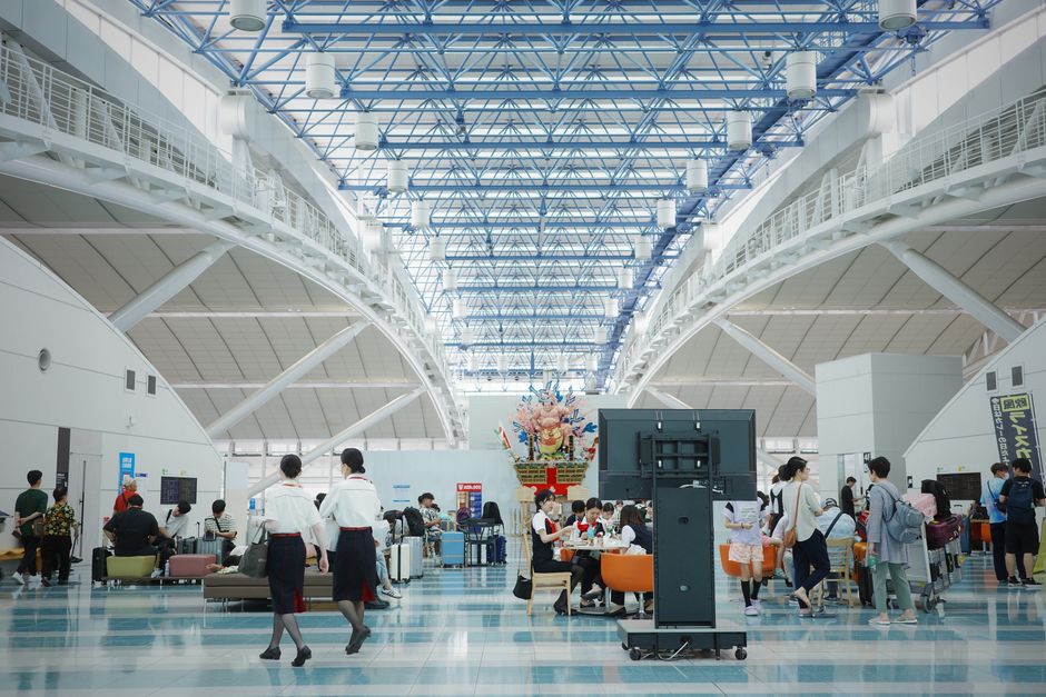 現代建築と旅行者を紹介する広々とした賑やかな福岡空港のロビー。