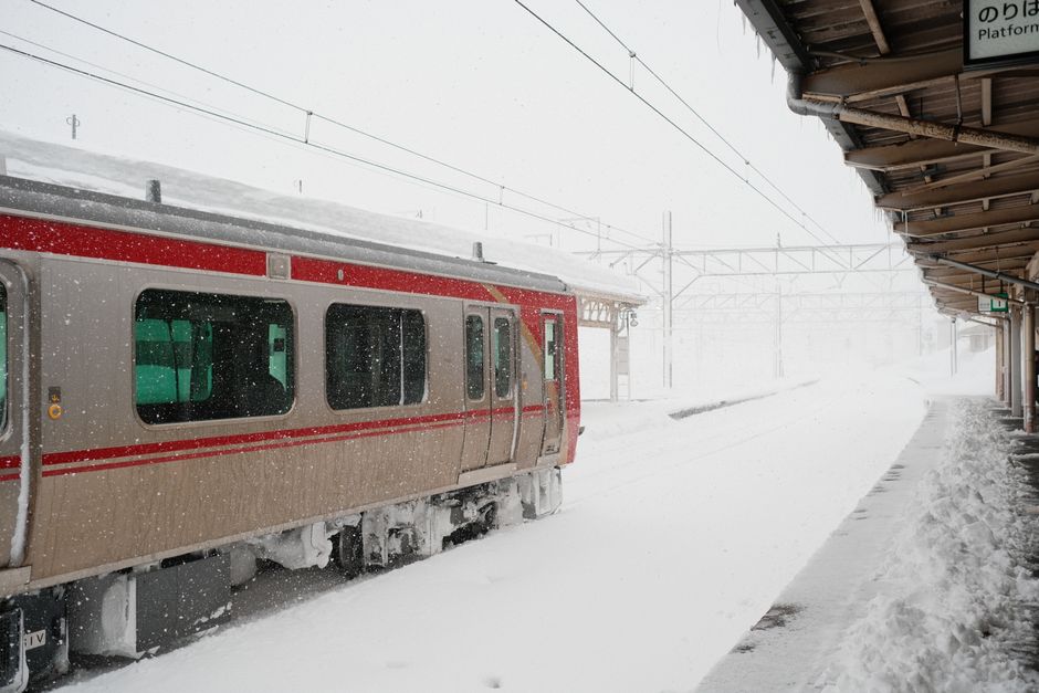 年末年始の旅で注意したい雪の駅を出発する列車